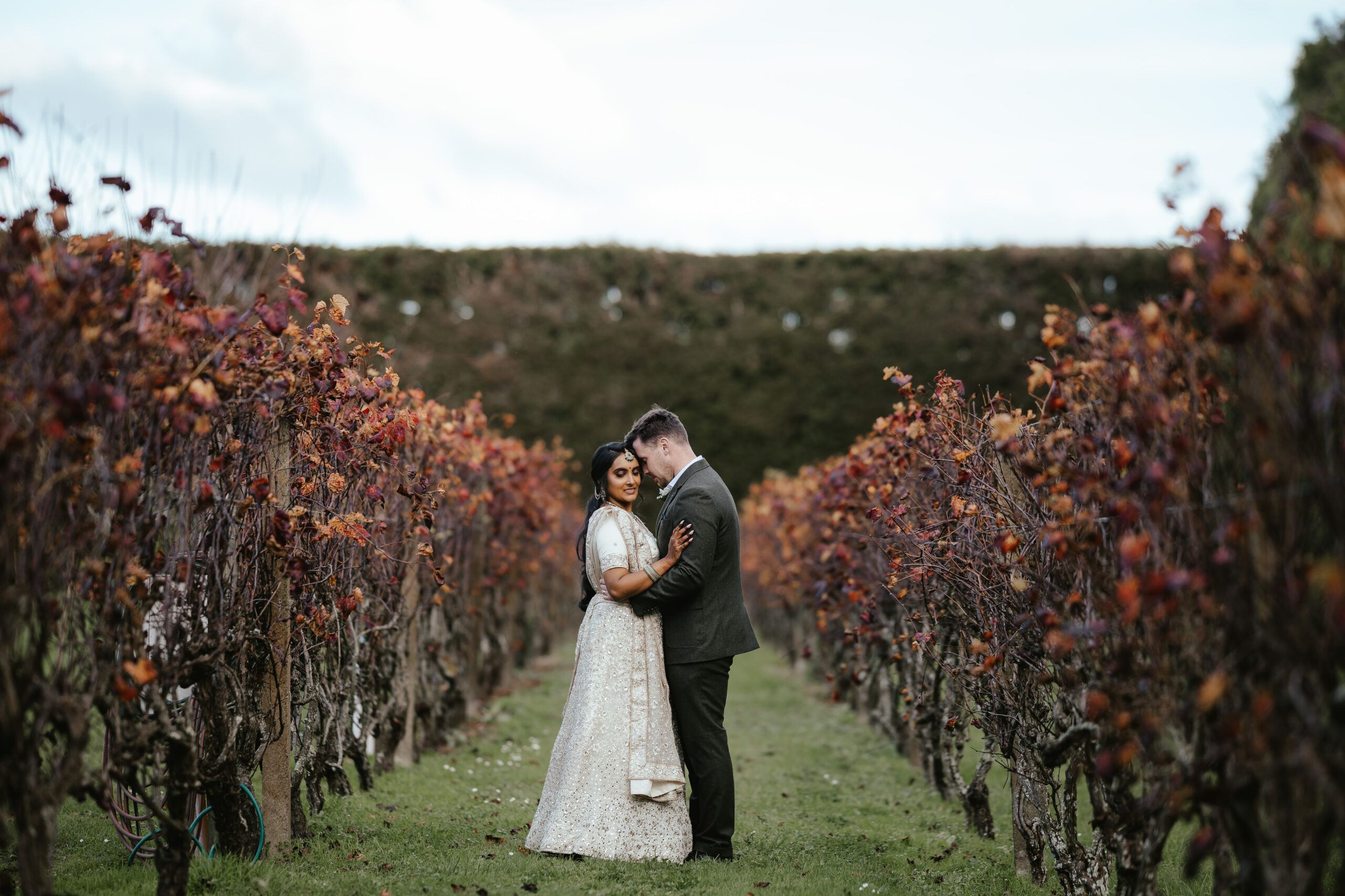 Bride and groom embracing in an autumn vineyard